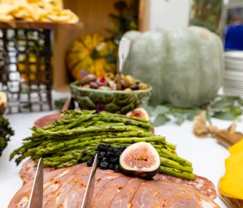 Carved meats and grilled asparagus presented on a cutting board. Photo by Bellini Studios.